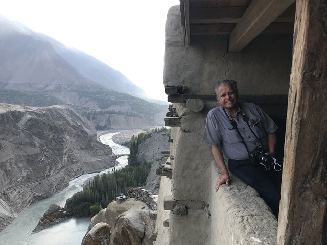       Person posing on a historical structure overlooking a valley.
  