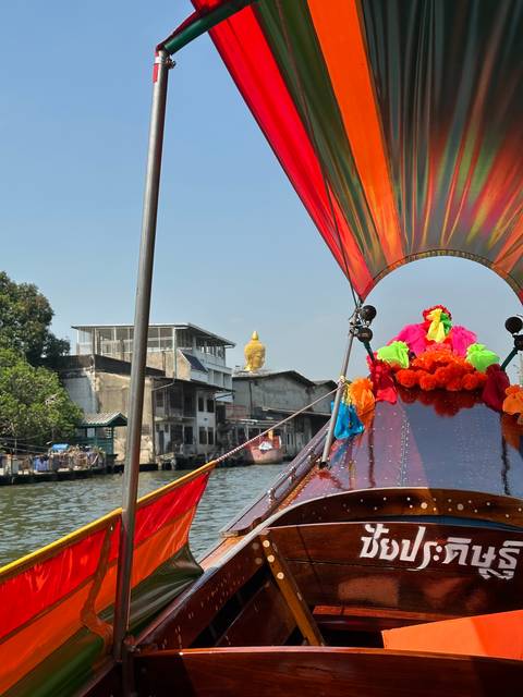       Boat with colorful decorations on a river.
  
