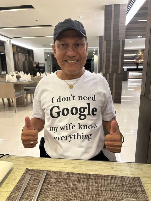       Man wearing a humorous shirt indoors.
  