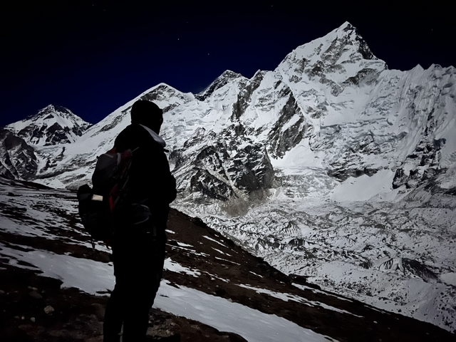       Person silhouetted against a mountainous night sky.
  