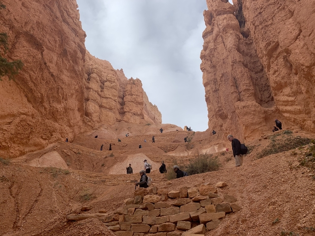 People walking on steps in a canyon.