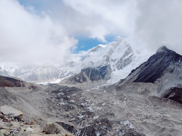 Mountain range with snow and clouds.