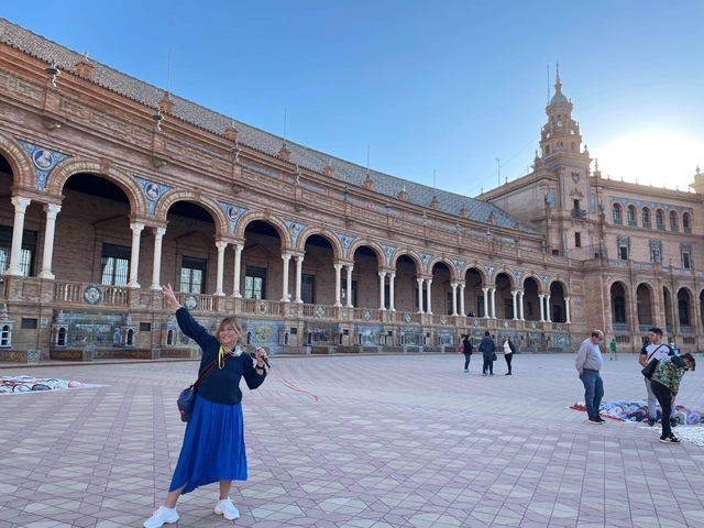 Person posing in front of a historical building
