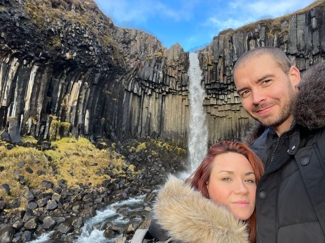 A couple in front of basalt columns waterfall