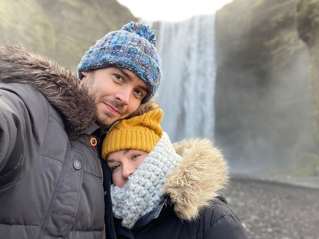 A couple embracing with a waterfall in the background