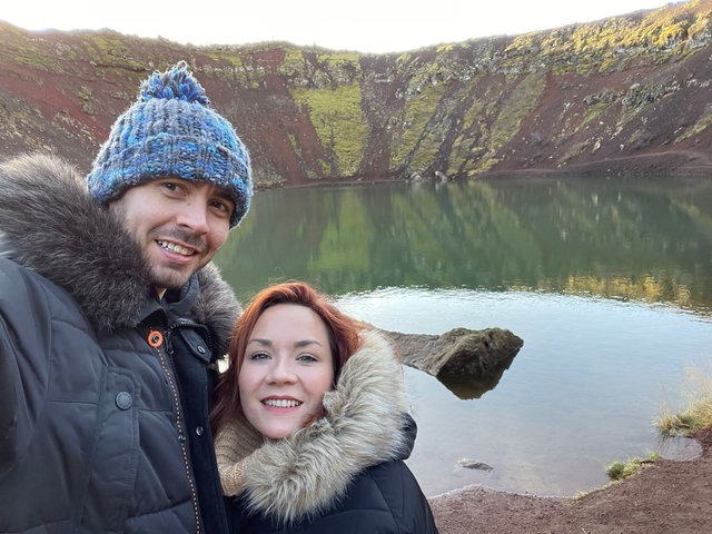A couple posing in front of a lake