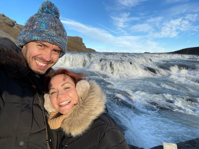 A couple with a waterfall in the background