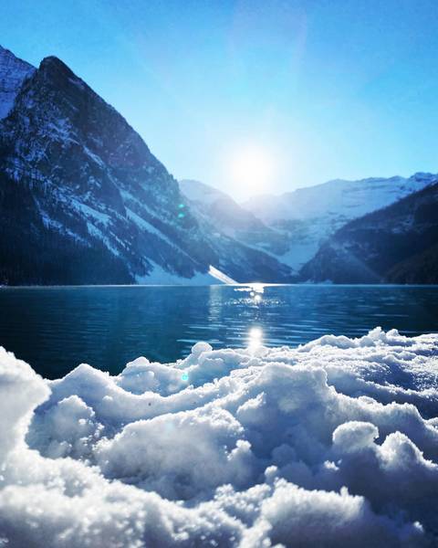Snow-covered mountains reflected in a pristine lake.