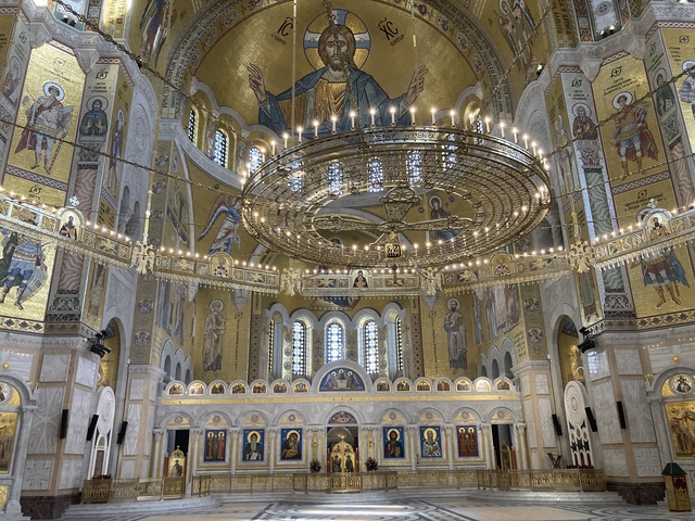       Interior of an ornate church with chandeliers.
  