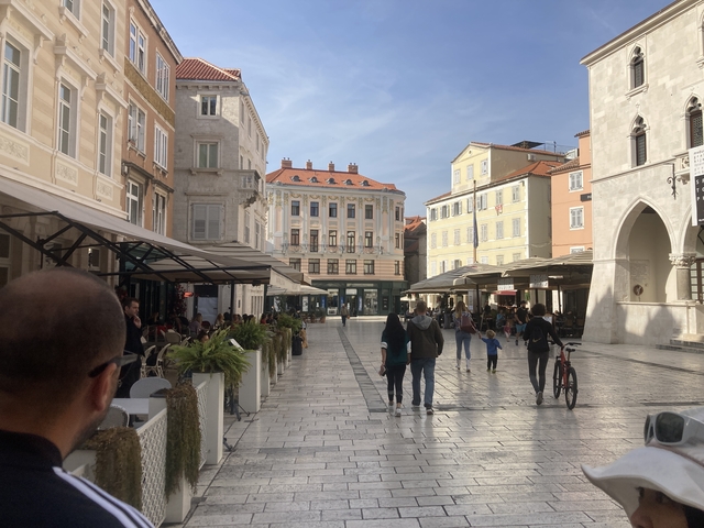       Central square in Split with people and bicycles.
  
