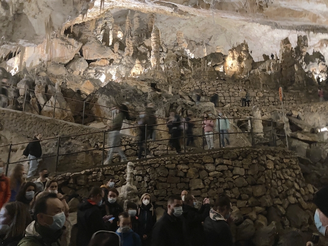       People exploring inside a limestone cave.
  