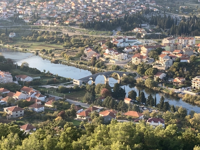       Aerial view of a town with a river and bridge.
  