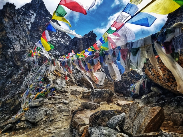 Colorful Tibetan prayer flags fluttering on a mountainside in Nepal.
