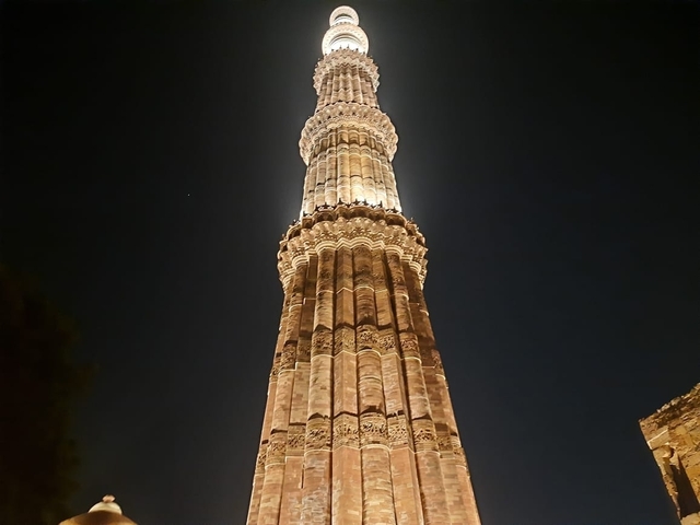 Night view of the Qutub Minar illuminated.
