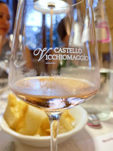      Close-up of a wine glass with 'Castello Vicchiomaggio' text.
  