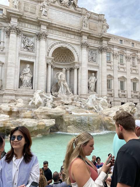       A crowded scene at the Trevi Fountain in Rome.
  
