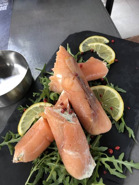       Dish of smoked salmon rolls garnished with lemon and greens.
  