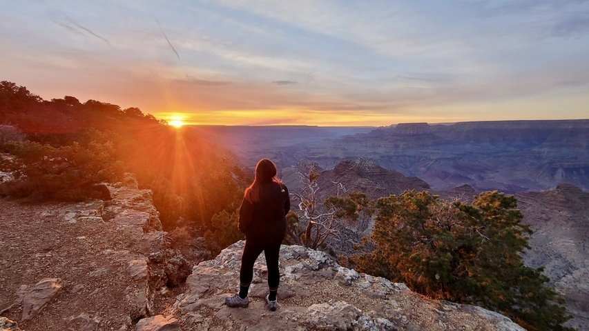Person watching a sunset over the Grand Canyon.