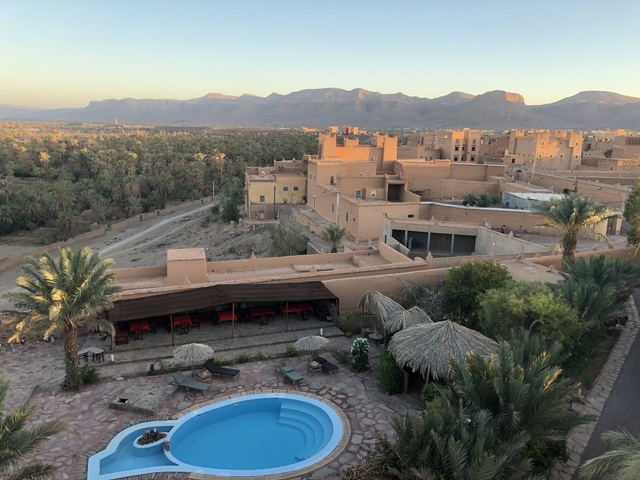       Aerial view of a desert oasis town with mountains.
  