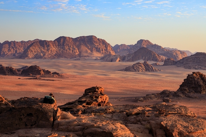 Vast desert landscape with a person admiring the view.