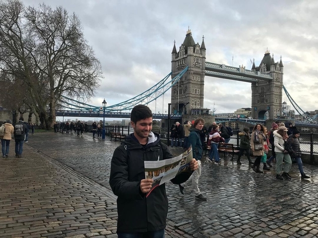 Man reading a map with the Tower Bridge in the background.