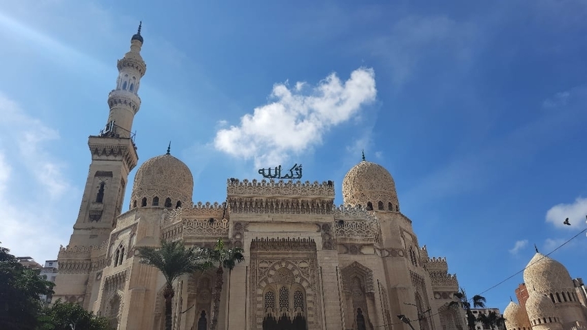       Beautiful mosque with detailed domes and minarets against a blue sky.
  
