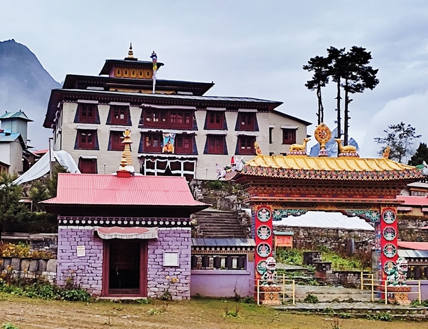       Colorful traditional Nepalese building with flags and gates.
  