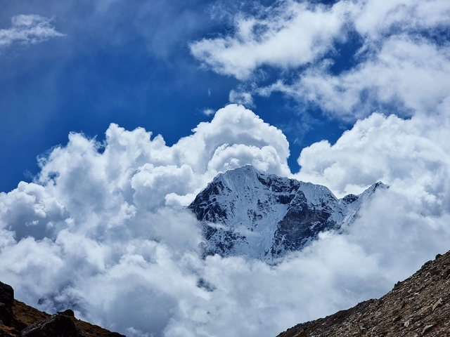       Snow-covered mountain peaks with clouds.
  