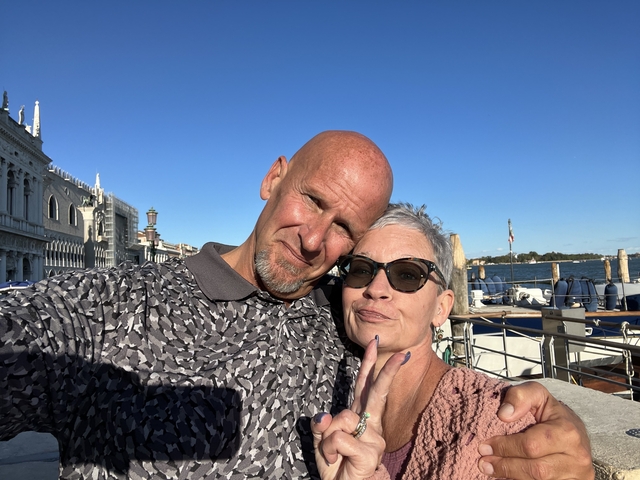 Couple taking a selfie by the waterfront on a sunny day.