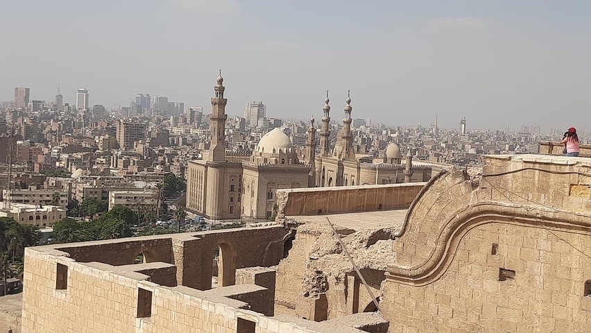       Aerial view of a city with mosques in the foreground.
  