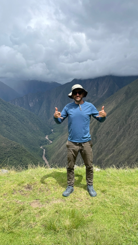 Man posing with peace gestures in the mountains.