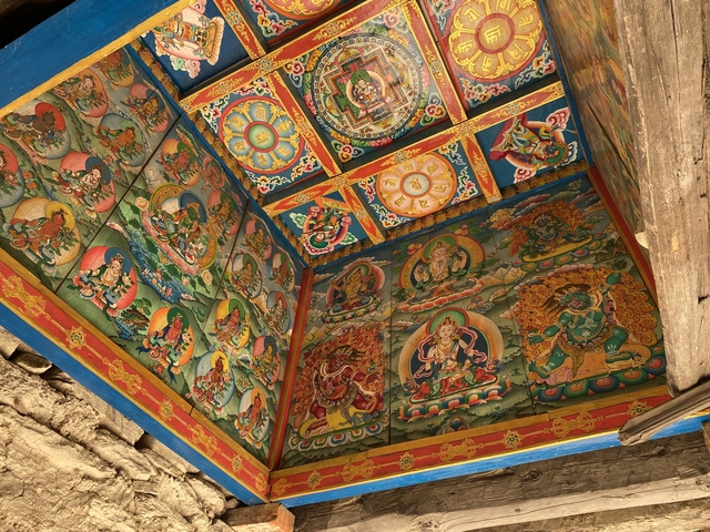       Intricate and colorful ceiling murals in a temple.
  
