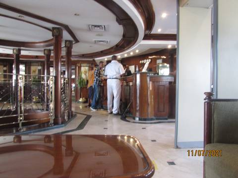       Interior of a building with people interacting around a wooden bar.
  