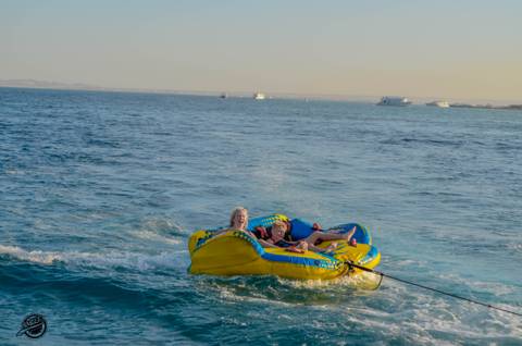 People enjoying a water activity on a yellow inflatable.