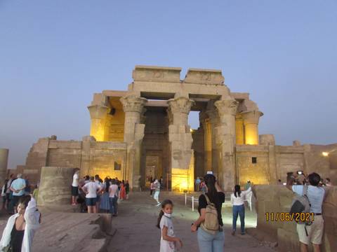       Kom Ombo Temple during twilight with people around.
  