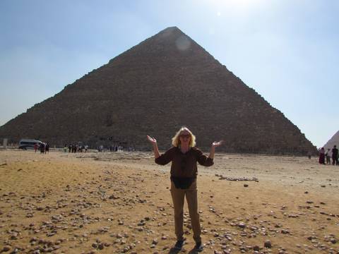       Woman posing in front of a pyramid at Giza.
  