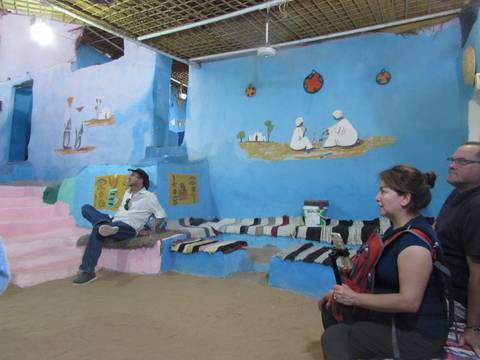       People sitting inside a colorful, decorated room.
  