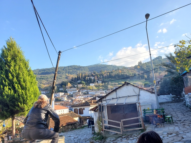       Small hillside town with white houses, a person in the foreground.
  