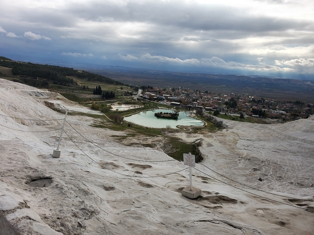       View from Pamukkale looking down on terraces and a small town.
  