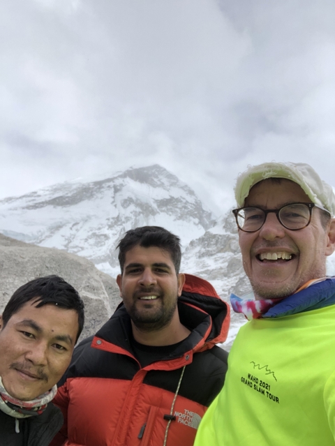 Two people with a snowy mountain background.