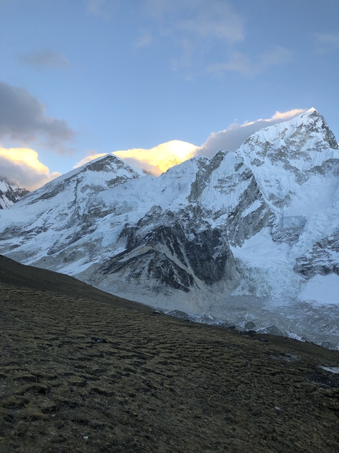 Snow capped mountain peaks during sunset.