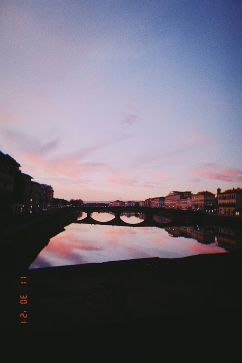       Silhouette of a bridge over a river at sunset.
  