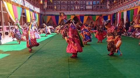       Bhutanese dancers performing traditional dance during a festival.
  