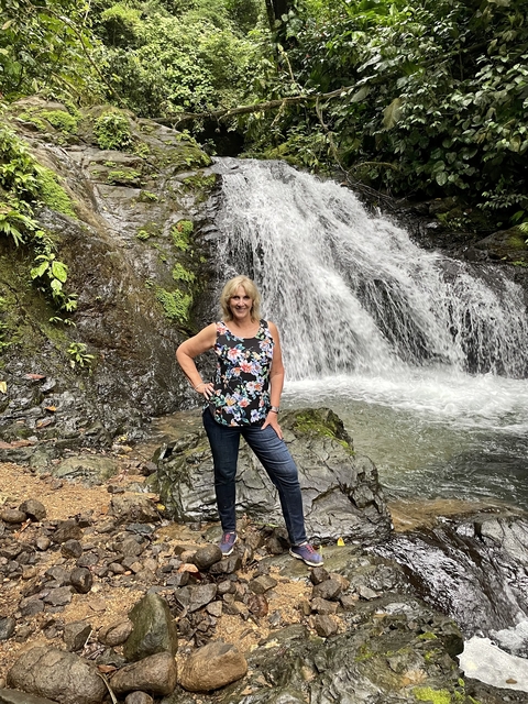 Person standing in front of a waterfall.