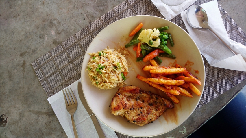       Plate of food featuring rice, vegetables, and grilled chicken.
  