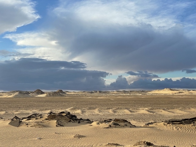 Expansive desert view with dramatic clouds.