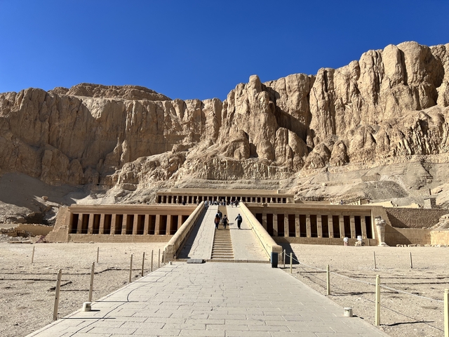       Mortuary Temple of Hatshepsut with tourists walking up the ramp.
  