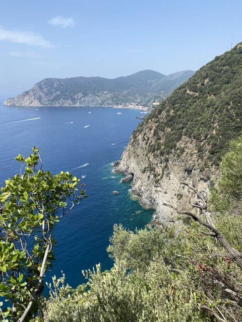       Coastal view with blue waters and green hills.
  