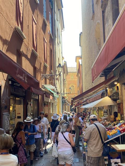       Busy market street with people shopping.
  