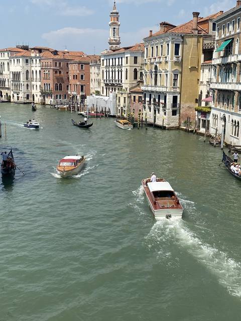       Boat traffic along a canal with historical buildings.
  